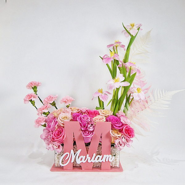 A stand with the name of a newborn and a bouquet of roses